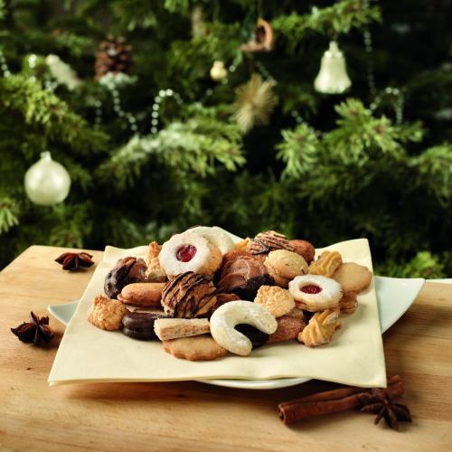 Piatto di biscottini natalizi sul tavolo davanti all'albero di Natale