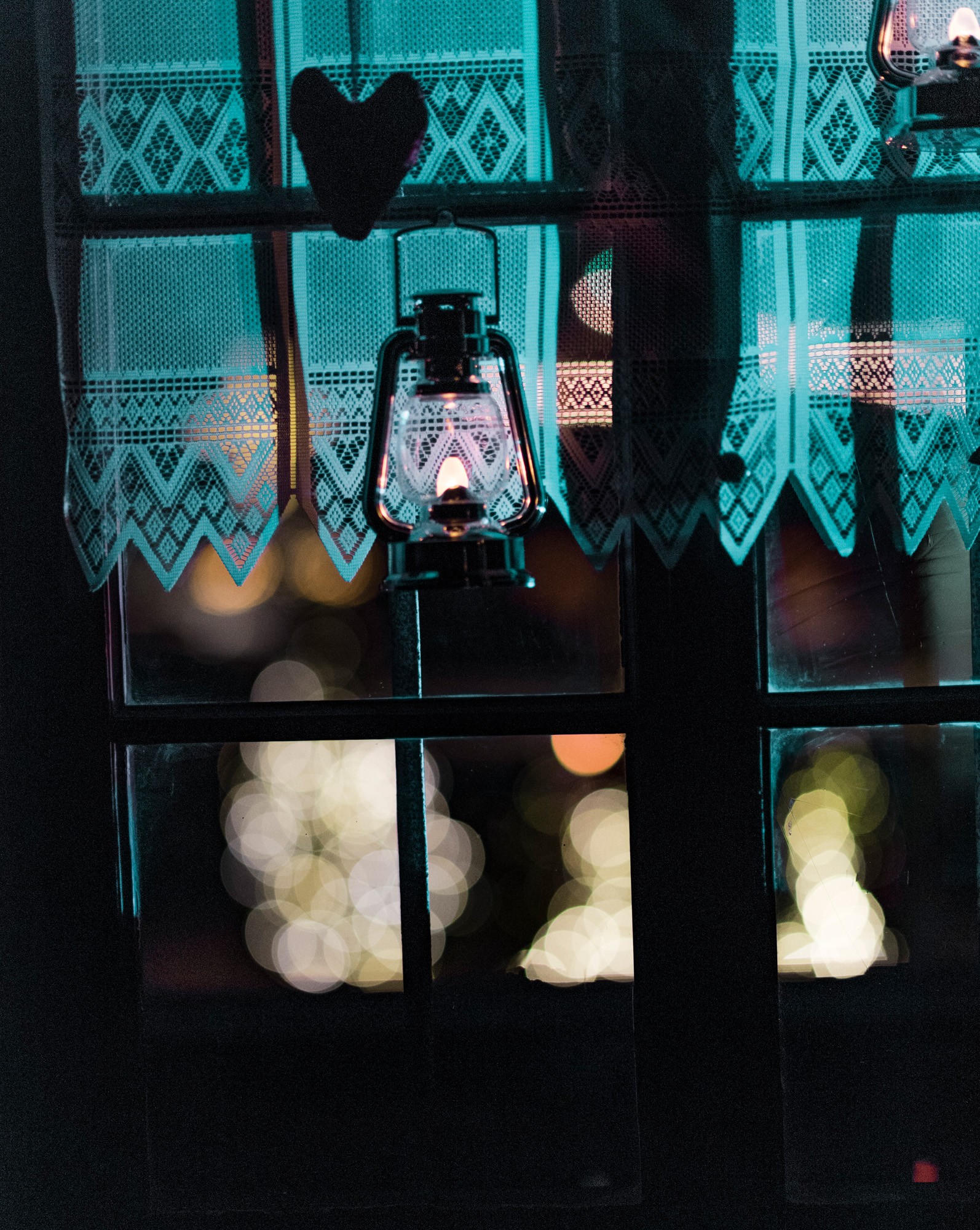 Luci di Natale in Tirolo, una finestra con una lanterna accesa e fuori, luci nel buio